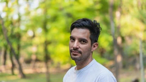 Man looking at camera smiling in nature park Stock Photos