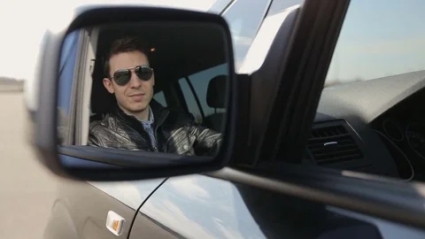 Man looking at camera through rear view mirror, man driving car, driver. Stock Footage 73998481