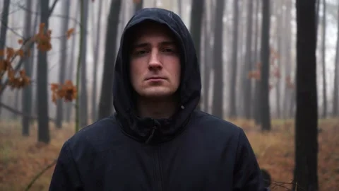 A man looking at the camera while standing in a foggy forest in the morning Stock Footage 167173106