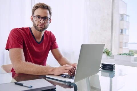Man looking at camera while working from home Foto stock