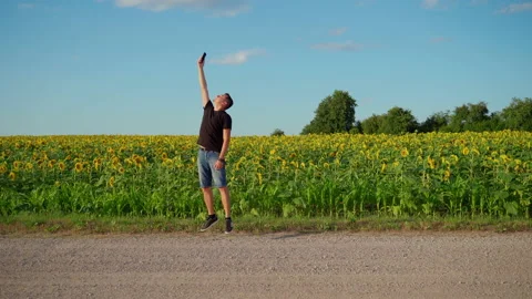Man looking for cellular Internet connection on rural road. Young adult person Stock Footage 157580412