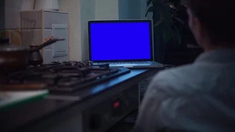 Man looking at chroma key notebook computer display at kitchen near stove Stock Footage 83253341