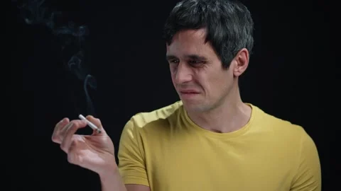 Man Looking at Cigarette with Disgust and Contemplation Stock Footage 295216522