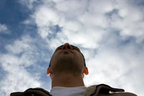 Man looking up with the clouds on the background Stock Photos