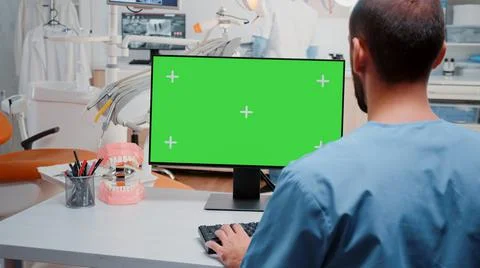 Man looking at computer with horizontal green screen Stock Photos