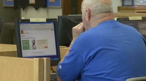 Man looking at computer in library Stock Footage 8981562