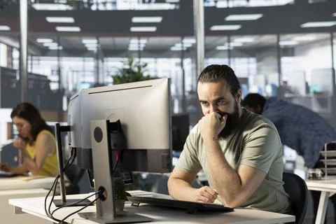 Man looking at computer screen in office, doing research for team project Foto stock
