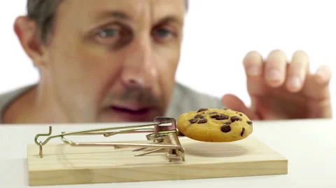 Man Looking at Cookie In Rat Trap Stock Footage 66488650