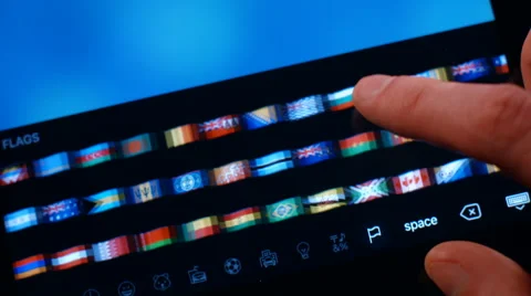 The man is looking at the correspondence flags of the countries on a Tablet PC. Video stock 62889079