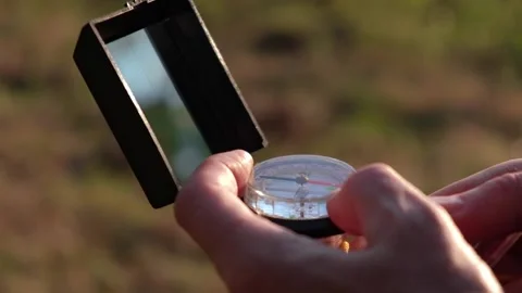 Man is looking for direction with compass in his hands. orientation on terrain. Stock-Footage 231473582