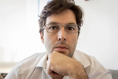 Man looking directly at the camera making a conference call. Stock Photos