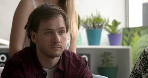 Man looking disappointed while watching televised sports match at home, slow Stock Footage 87465669