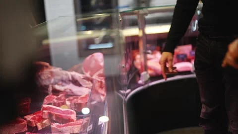 A man is looking at a display of meat in a butcher shop Stock Footage 301517920