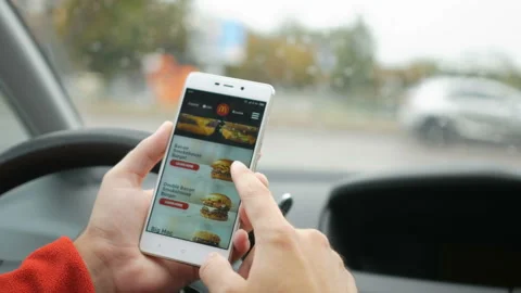 Man looking for diverse menu and mccafe in the McDonalds app before ordering  Stock Footage 100604265