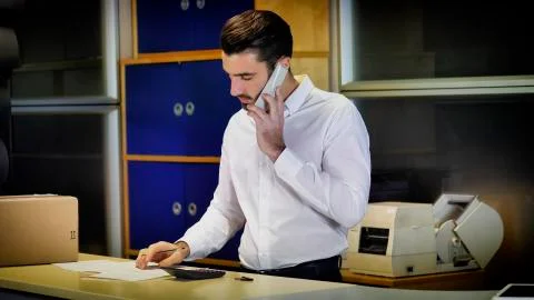 Man looking at documents at office counter Stock Photos