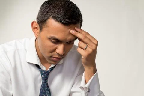 Man Looking Down and Depressed with Fingers Touching Head Stock Photos