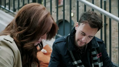 Man looking down and talking to woman while pointing at book Stock Footage 130602651