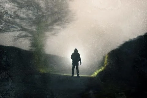 A man looking down a country road, silhouetted against torch light. 스톡 일러스트