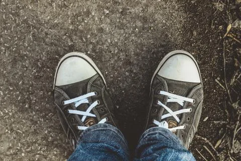 Man looking down to his grey trainer shoes Stock Photos