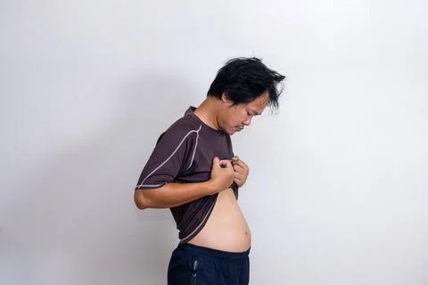 A man looking down at his pants when he was fat. Stock Photos