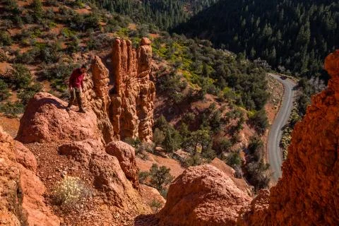 Man looking down over dangerous cliff near Saint George, Utah among red rock  Stock Photos