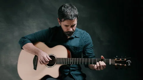 Man looking down playing guitar Stock Footage 130734774