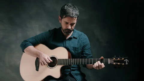 Man looking down playing guitar Stock Footage 130788620