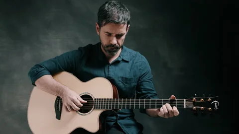 Man looking down playing guitar Stock Footage 130788658