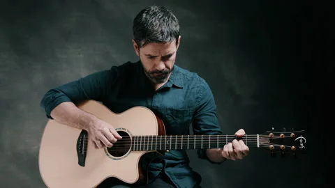 Man looking down while playing guitar Stock Footage 130734926