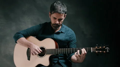 Man looking down while playing guitar Stock Footage 130734955