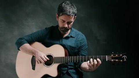 Man looking down while playing guitar Stock Footage 130735043