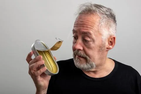 Man looking at an empty sardine can Stock Photos