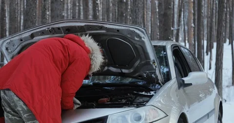 Man looking at engine of car. man repairing broken car. Winter Driving, trouble Stock Footage 101935488
