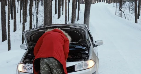 Man looking at engine of car. man repairing broken car. Winter Driving, trouble Stock Footage 101935545