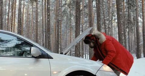 Man looking at engine of car. man repairing broken car. Winter Driving, trouble Stock Footage 101935861
