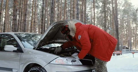 Man looking at engine of car. man repairing broken car. Winter Driving, trouble Stock Footage 101936027