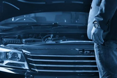 Man looking on the engine of a car with open hood Foto stock