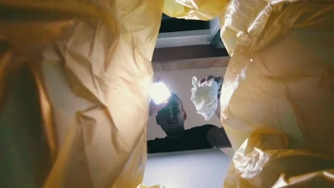 A man is looking with a flashlight in a trash can 動画素材 131222767