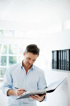 Man looking at folder of paperwork Foto stock
