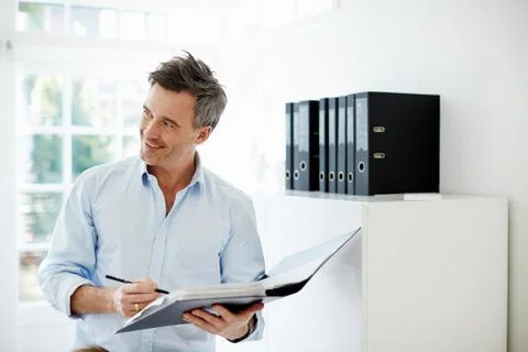 Man looking at folder of paperwork Stock Photos