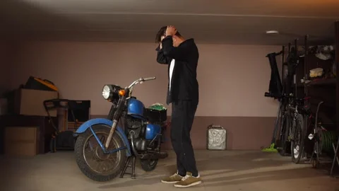 Man looking frustrated with hands on head, standing next to a broken vintage Stock Footage 342774371