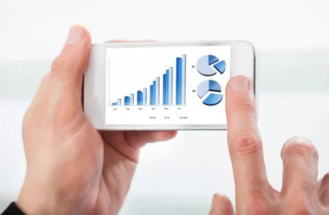 Man looking at a graph on his mobile phone 写真素材