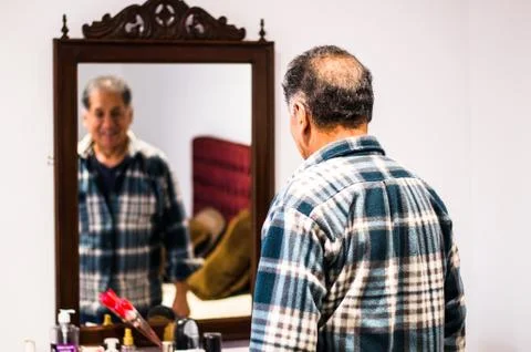 Man looking at himself in the mirror smiling Stock Photos