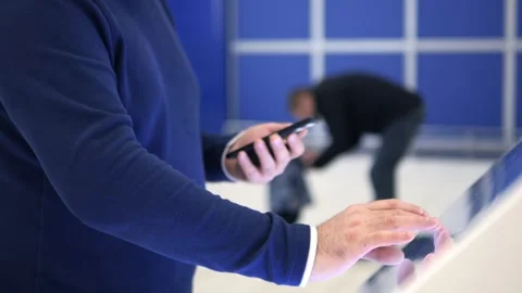 Man is looking at his cell phone while walking down a hallway Stock Footage 297492312