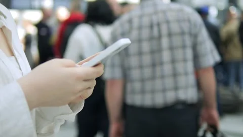 Man is looking at his cell phone while walking down a crowded street Stock Footage 310788351