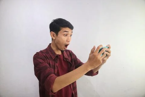 A man looking to his handphone with surprised expression Stock Photos