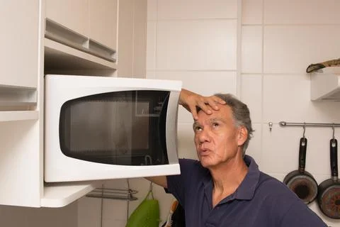 Man Looking into his Micrwave Stock Photos