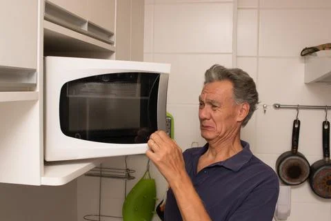 Man Looking into his Micrwave Stock Photos