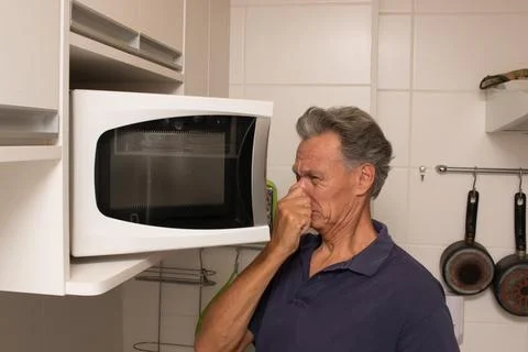 Man Looking into his Micrwave Fotos de archivo