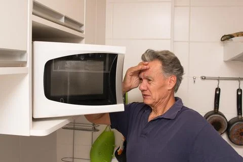 Man Looking into his Micrwave Stock Photos